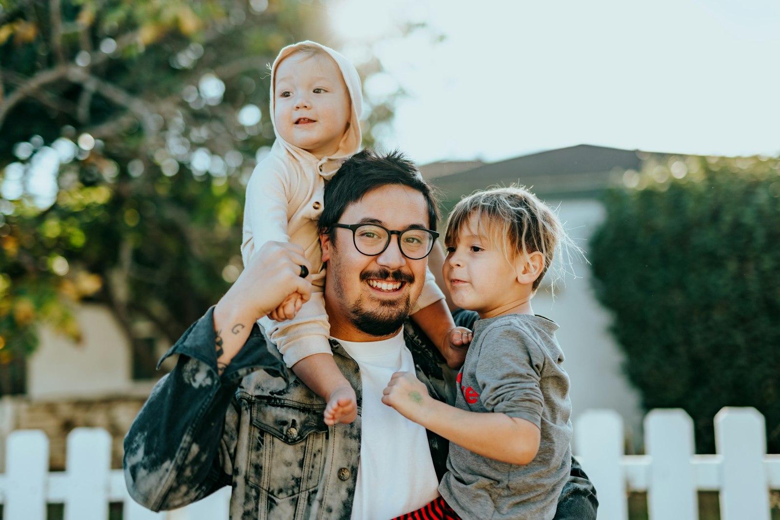 Parent with children smiling outside their home