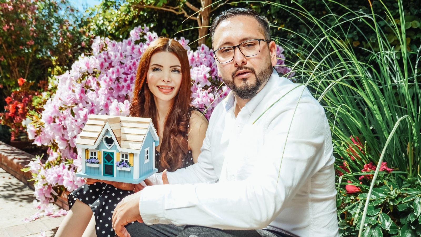 Couple holding a model home while planning their mortgage